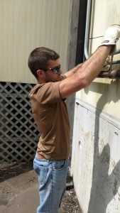 HVAC students from Northeast Technical Institute working at Debesta Pizza to install new equipment. One student is adjusting a pipe fitting.